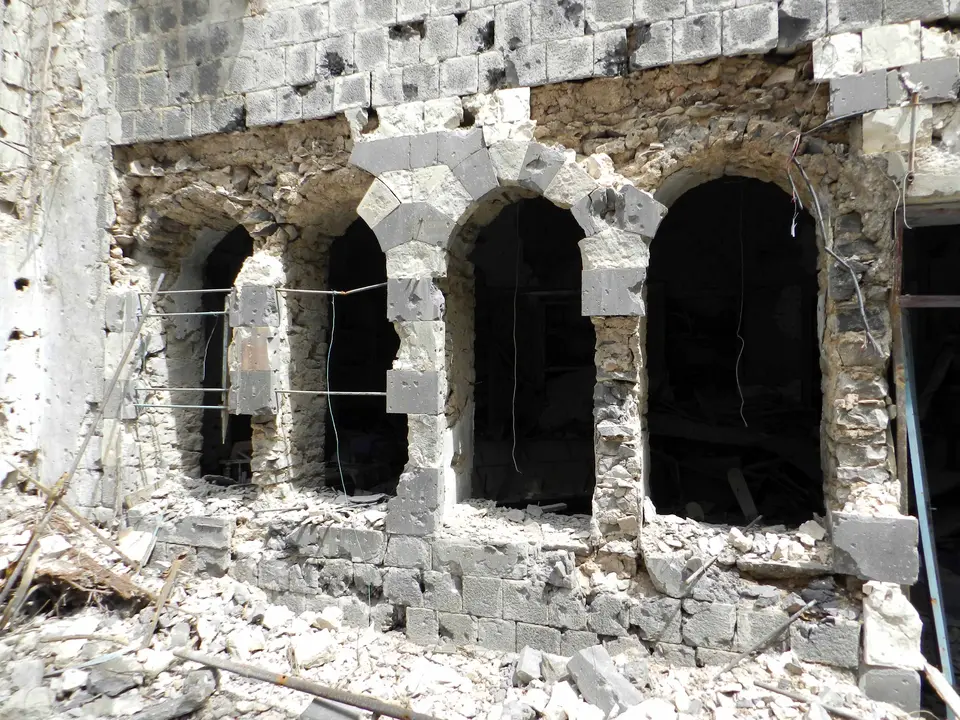 Rubble and damaged stone buildings in a street in Homs.