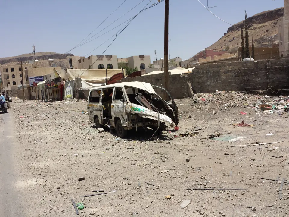 Damaged buildings, wrecked vehicles and debris in a residential area of Sana’a.